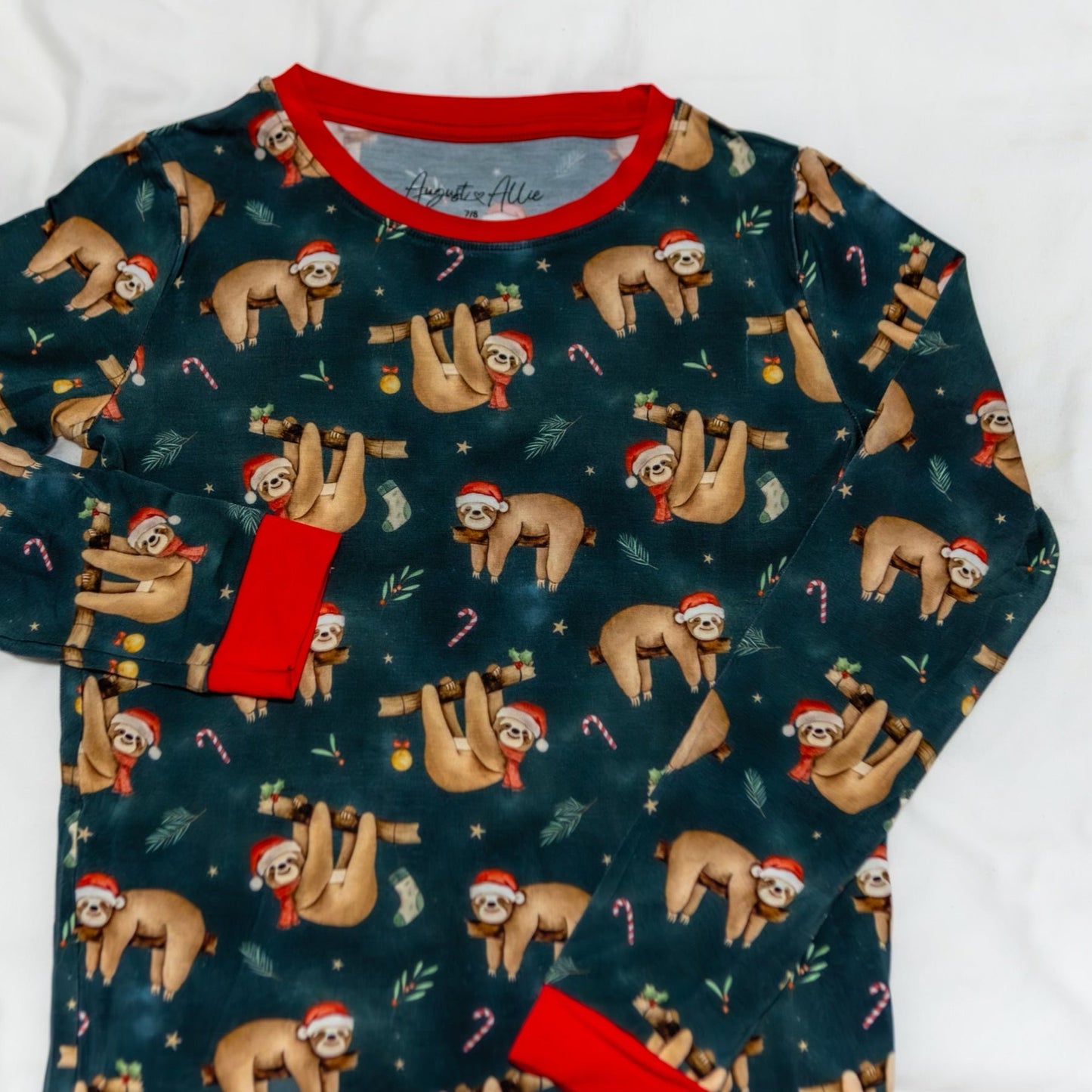 Long-sleeve shirt with Christmas sloth pattern on a white background