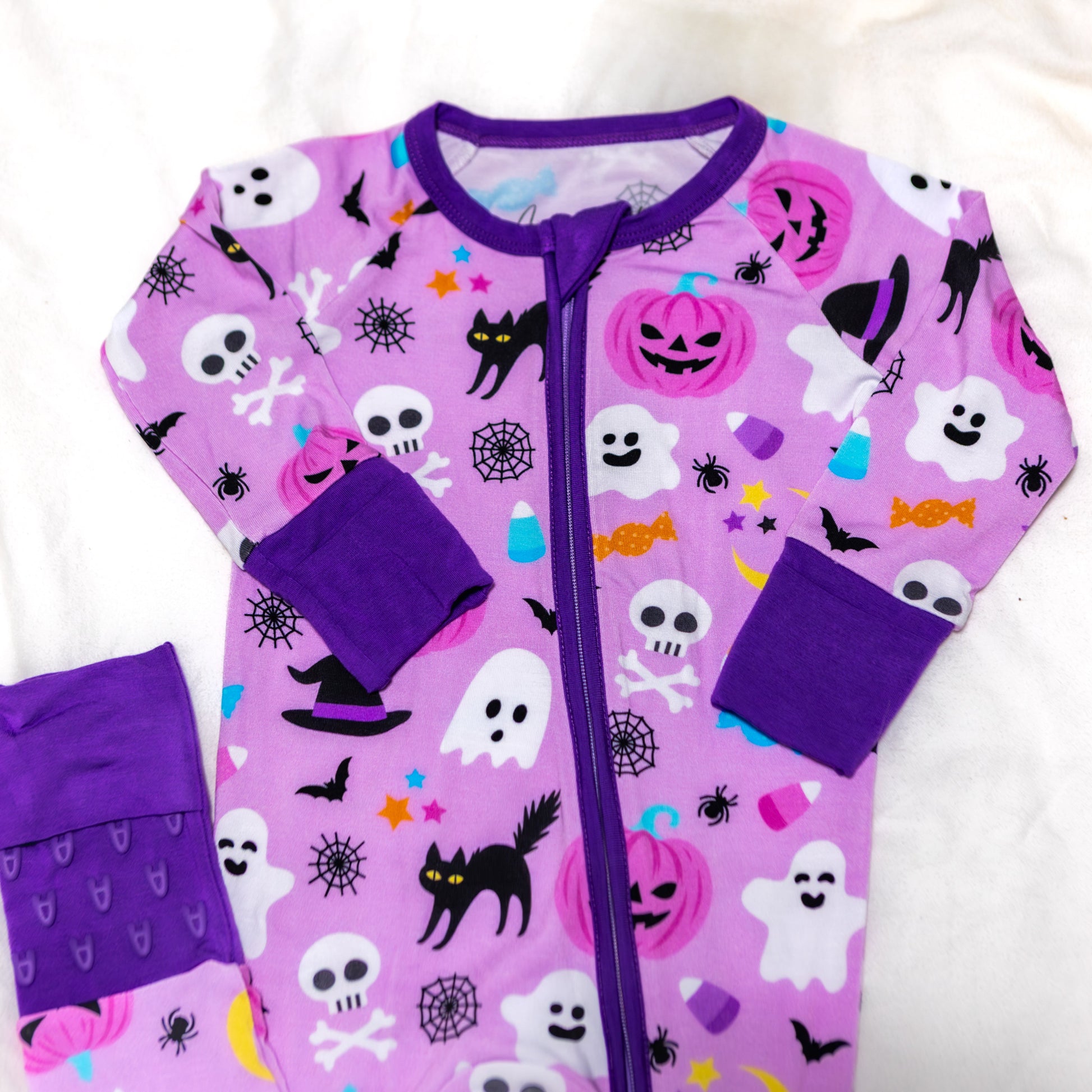 Purple Halloween-themed baby onesie with colorful graphics on a white background